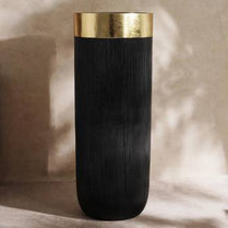 Black vase with gold rim on a neutral background