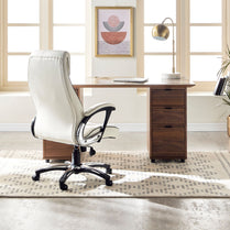 Wooden desk with white office chair in a bright room with large windows.