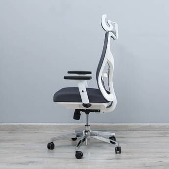 Black office chair with white backrest on a gray floor and wall