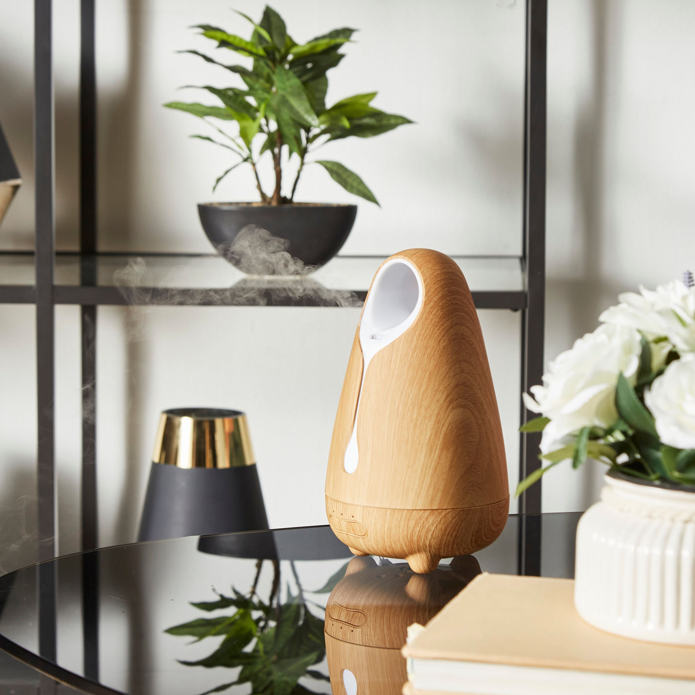 Wooden diffuser on a table with decorative items in the background