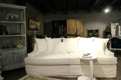 White sofa in a room with wooden walls and various decor items. Bodrum Collection Sofa – Elegance Meets Everyday Comfort | Vella Concept