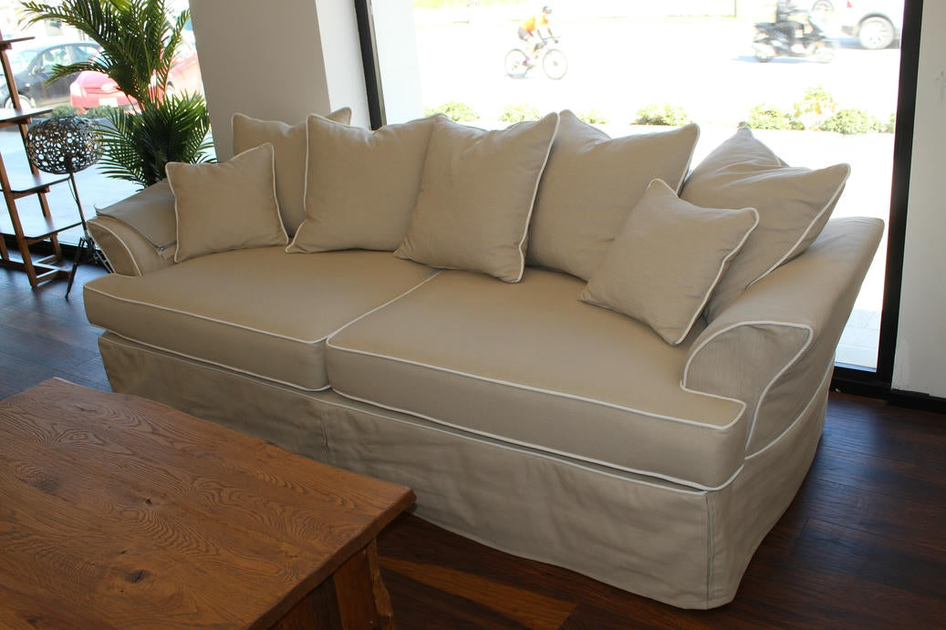 Beige sectional sofa with multiple cushions in a room with large windows. Bosphorus Collection Sofa – Minimalist Elegance for Modern Homes | Vella Concept