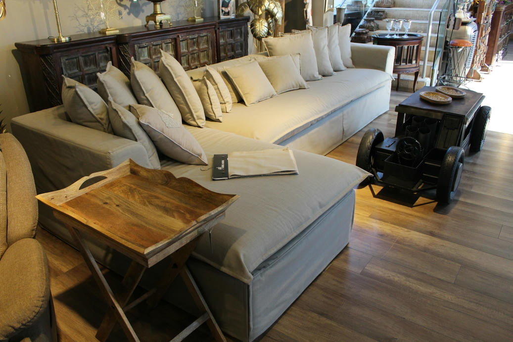 Living room with beige sofa, wooden coffee table, and decorative items. Cappadocia Corner Sofa – Elegant Comfort for Modern Living | Vella Concept