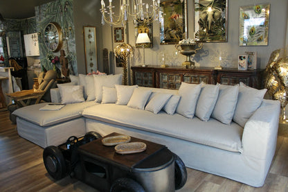 Gray sectional sofa in a room with decorative elements and furniture. Cappadocia Corner Sofa – Elegant Comfort for Modern Living | Vella Concept