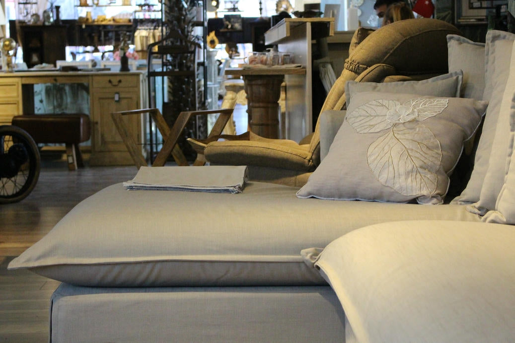 Gray sofa with decorative pillows in a store setting - Cappadocia Corner Sofa – Elegant Comfort for Modern Living | Vella Concept