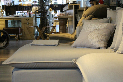 Gray sofa with decorative pillows in a store setting - Cappadocia Corner Sofa – Elegant Comfort for Modern Living | Vella Concept