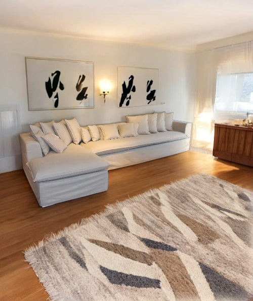 Modern living room with a white sofa, abstract art, and a patterned rug. Cappadocia Corner Sofa – Elegant Comfort for Modern Living | Vella Concept