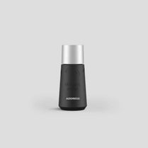 Black and silver bottle with 'ADDRESS' branding on a light gray background