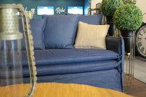 Blue sofa with a beige pillow in a room with decorative elements. Istanbul Collection Sofa – Minimal Touch, Maximum Comfort | Vella Concept
