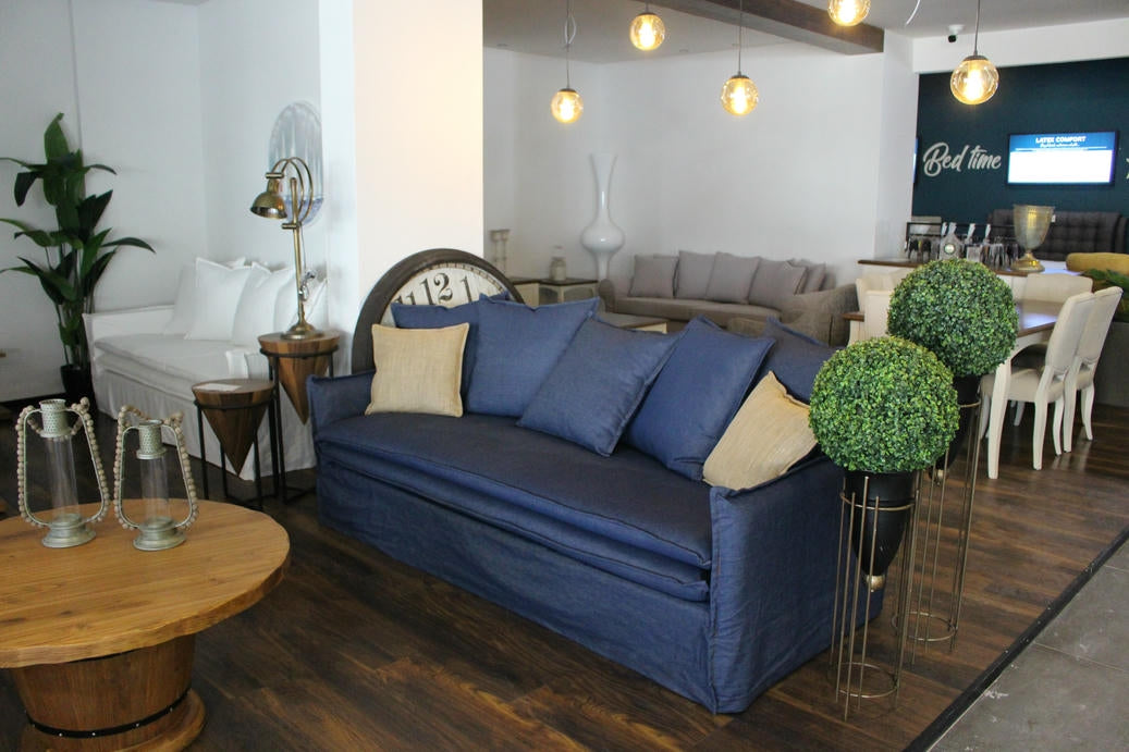 Living room with blue sofa, wooden coffee table, and decorative elements. Istanbul Collection Sofa – Minimal Touch, Maximum Comfort | Vella Concept