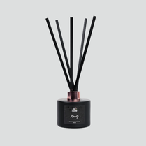 A black reed diffuser with a rose gold base and several reeds extending from the top. The label on the front displays 'MOODY'.
