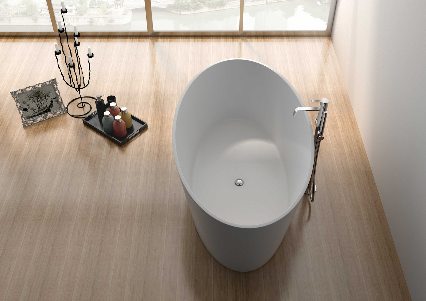 A white, freestanding, rectangular bathtub placed on a wooden floor with a chrome shower head and hanging wall decor in the background.